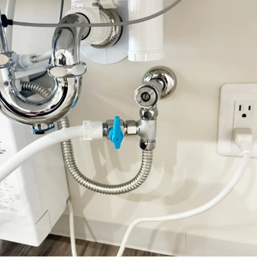 洗面台に追加設置した様子の写真(洗面台の下部分の配管と電源の様子を撮影)