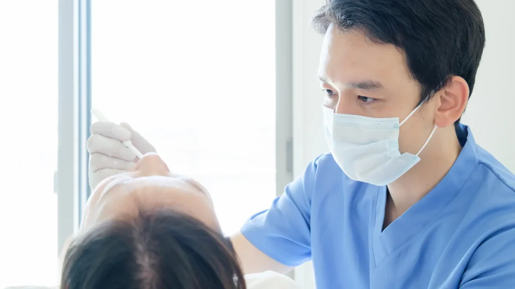 歯科医師が噛まれないか注意している様子の写真